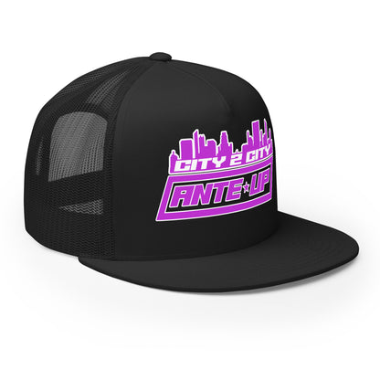 Three-quarter angled front view of a black trucker cap displaying the vibrant purple City 2 City logo and breathable mesh sides.